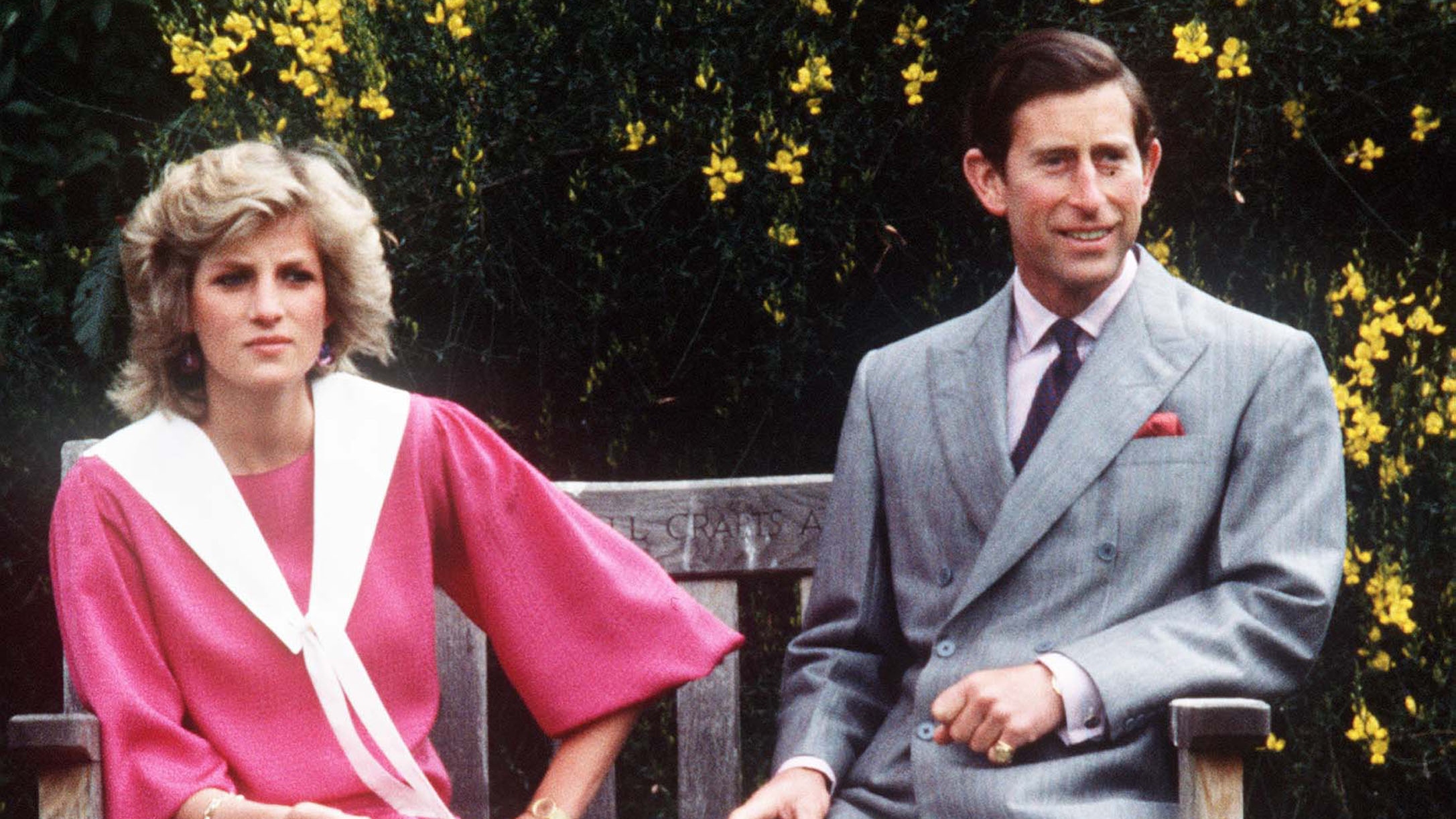King Charles and Diana, Princess of Wales, while 6 months pregnant with Prince Harry, sit on a wooden bench