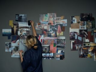 woman from behind, with hand up to mood board