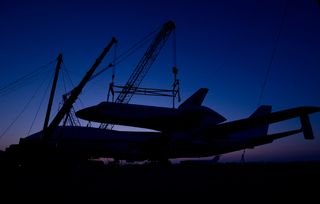 The prototype space shuttle Enterprise is seen in silhouette after it was mated on top of the NASA 747 Shuttle Carrier Aircraft (SCA) at Washington Dulles International Airport, Friday, April 20, 2012, in Sterling, Va.