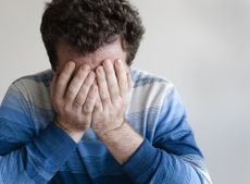 Sad man with head in hands. 