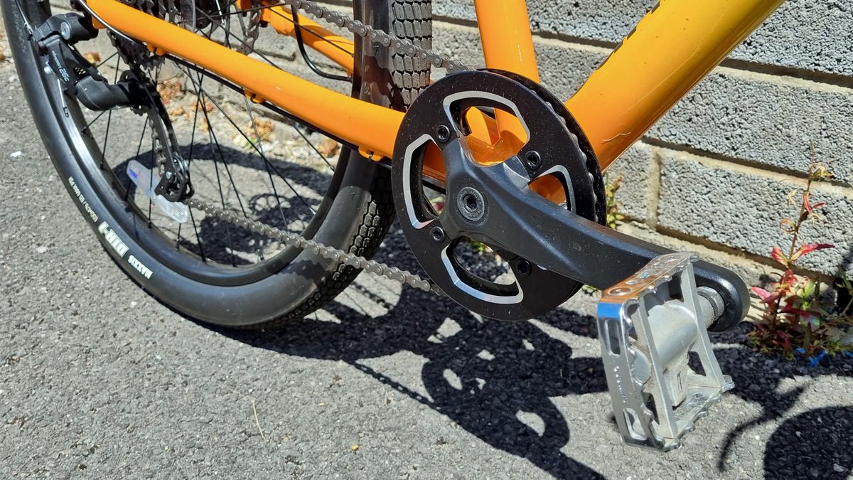 A close up of a single ring crankset on a yellow and orange bike