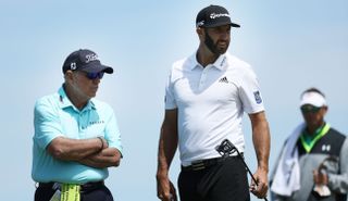 Harmon and Dustin Johnson watch on while DJ holds his putter