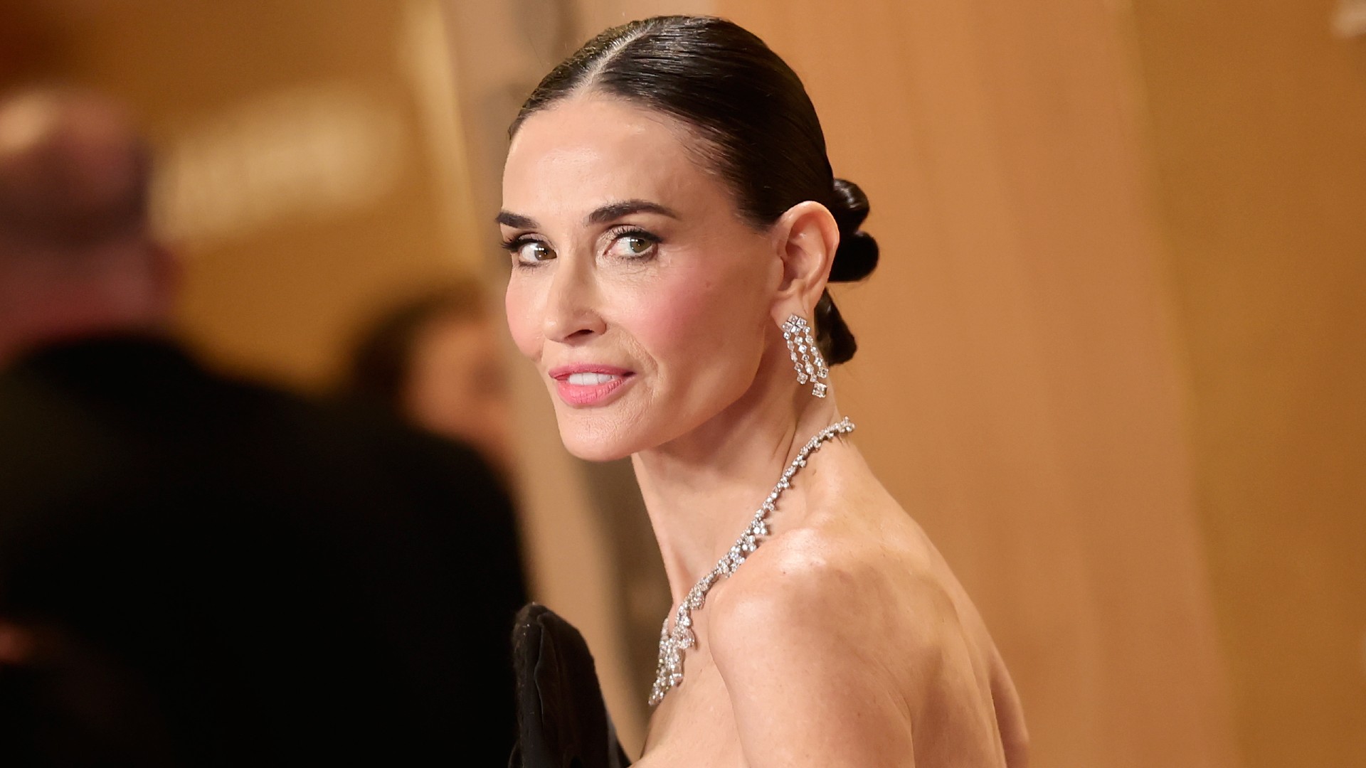 a white woman with dark hair poses for photos during an awards show