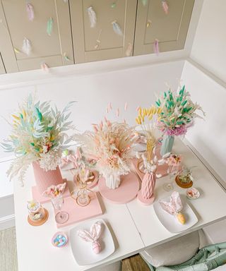 Pretty, modern pastel table styling with pastel vases filled with colored dried florals, and cute bunny ears place setting idea.