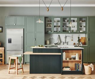 green kitchen with central dark green kitchen island with narrow shelf running around base at bar stool height