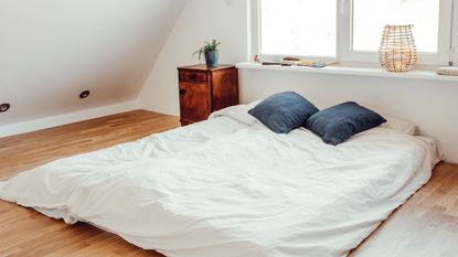 Mattress on floor in attic bedroom