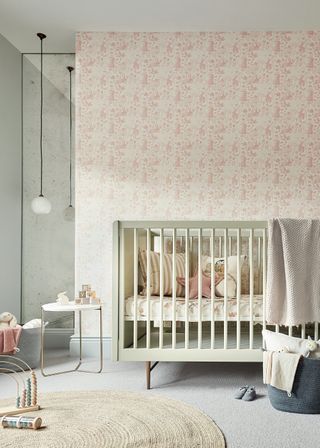 baby girl nursery with pink bunny wallpaper, pale green cot, pale grey carpet, rugs, toys, blankets