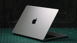 MacBook Pro 14-inch (2023) in a studio with lid partially closed showing Apple logo