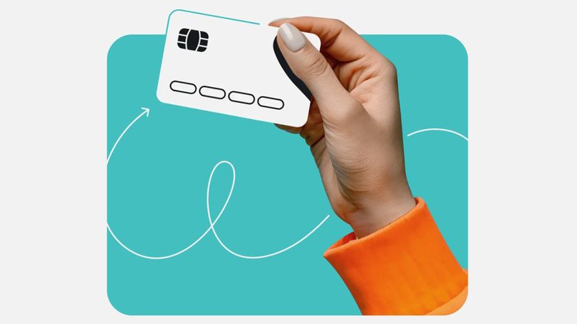 A hand holding a credit card to represent the Surfshark Alert security feature.