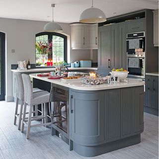 grey kitchen with blue cabinets and hanging lights