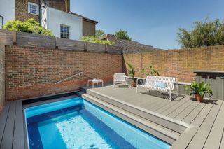 decked garden with small swimming pool with brick wall