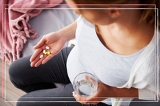 Pregnant women holding vitamins and supplements in her hand