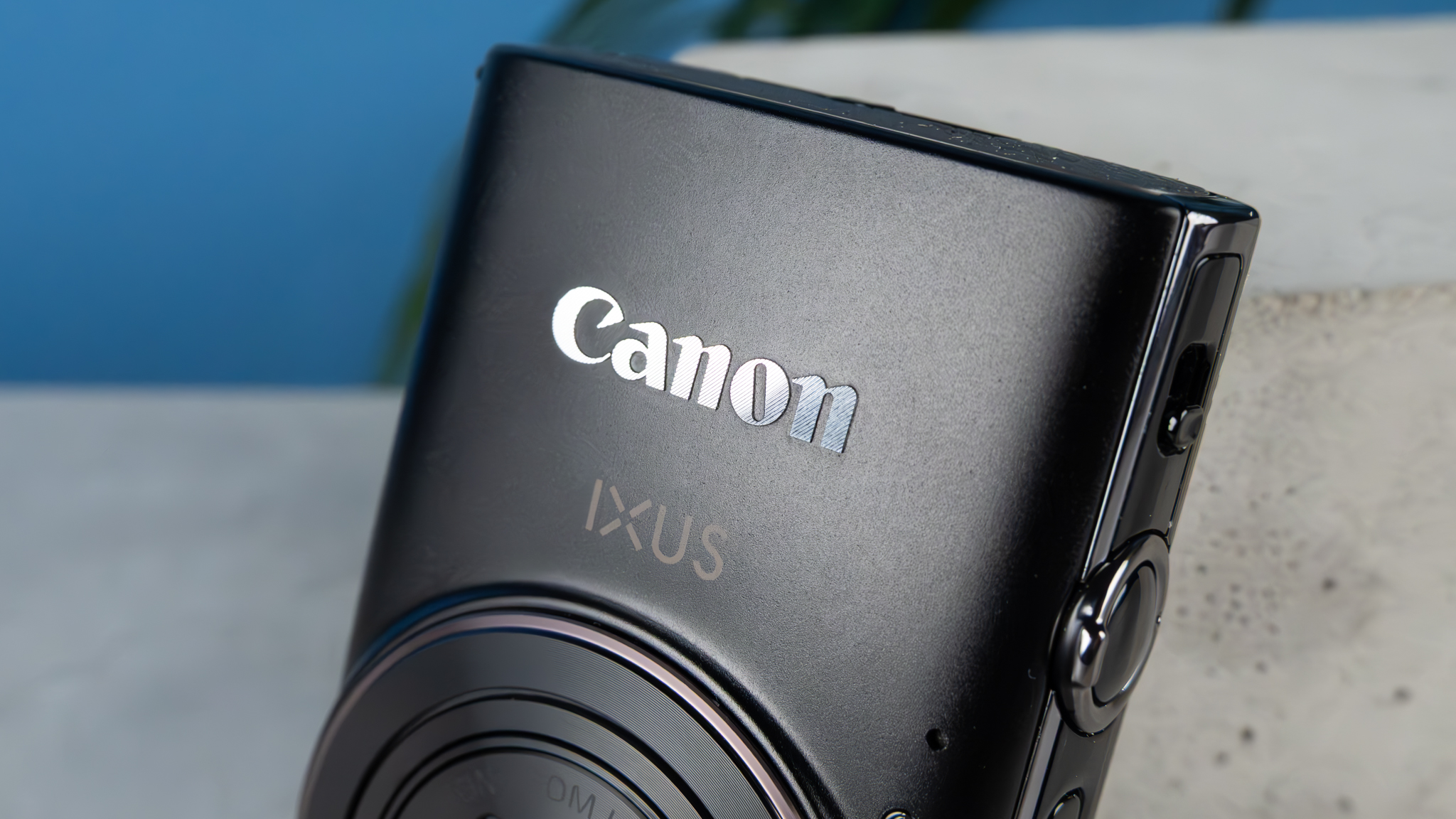 A black Canon PowerShot Elph 360 HS A or Canon PowerShot IXUS 285 HS A compact camera