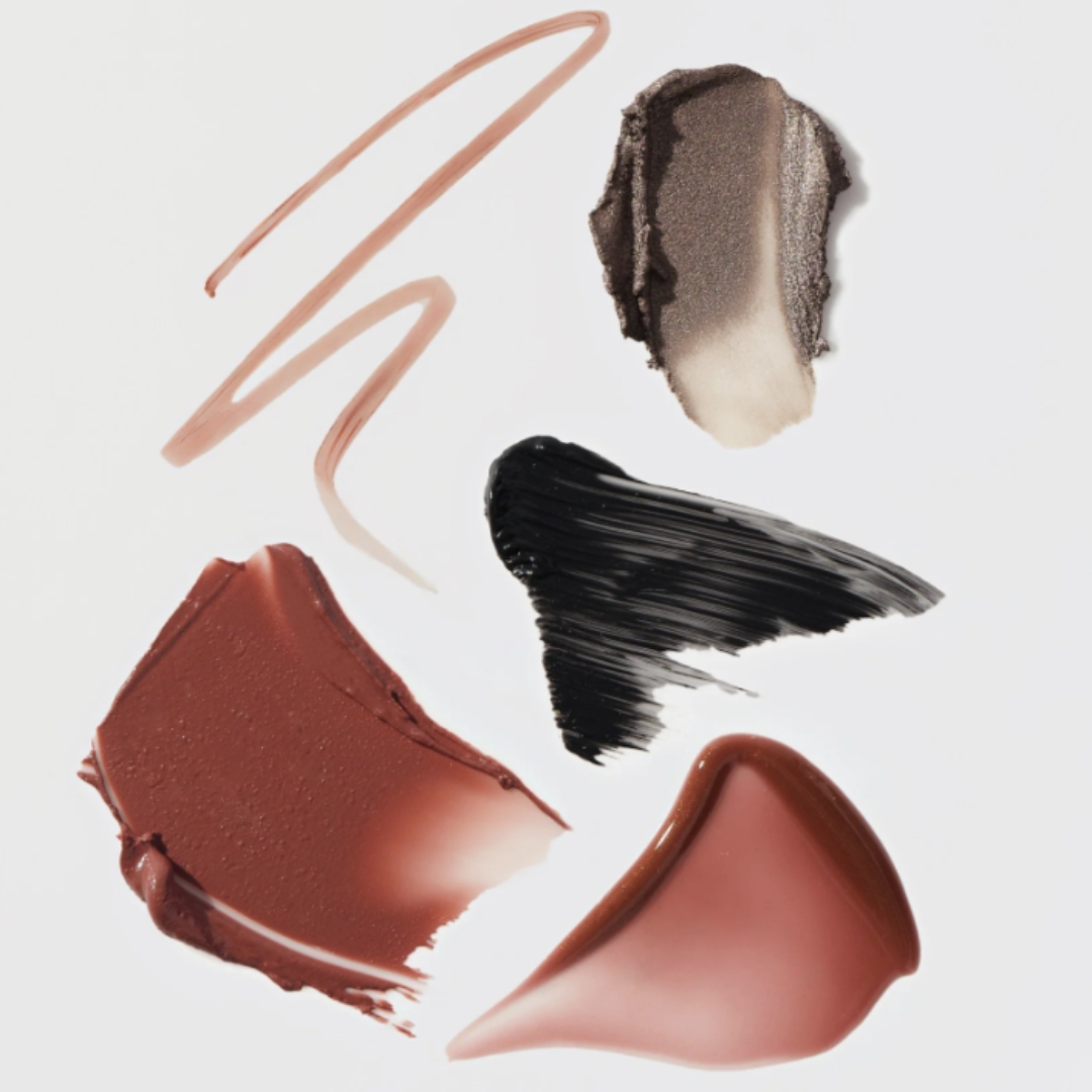 A collection of makeup swatches from Merit&#039;s The Winter 2025 Set, including a warm rose lip liner, flush balm and lip oil swatch, as well as silver-taupe eyeshadow swatch and black mascara streak.