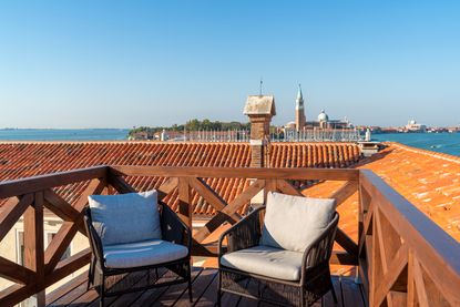 Armchairs on wooden altana, or roof terrace, at Venice hotel Ca’ di Dio, with view