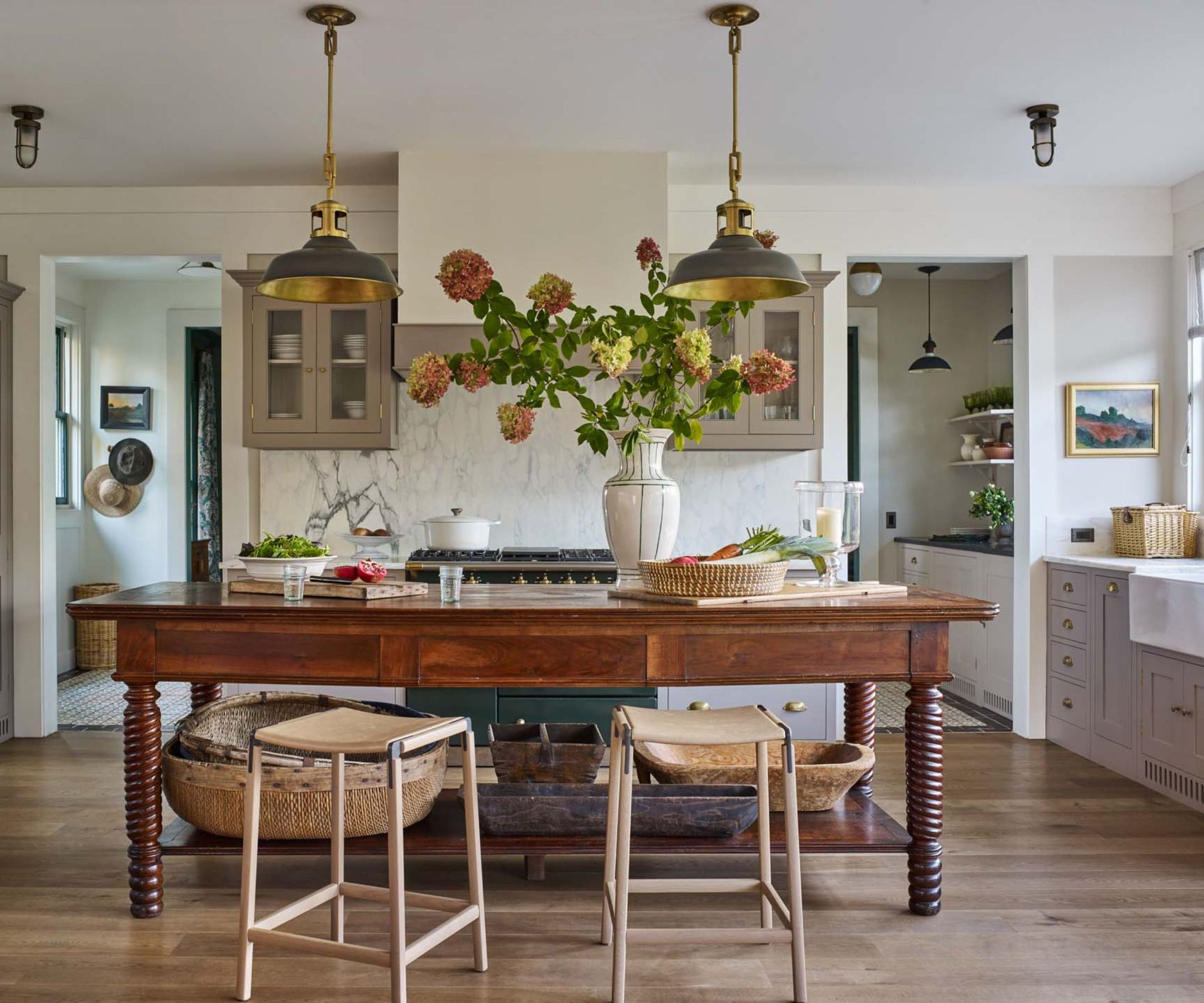 A midimalist kitchen with neutral colors, layered materials, and collected decor