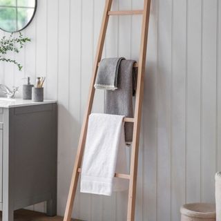 Wooden towel ladder leaning against bathroom wall