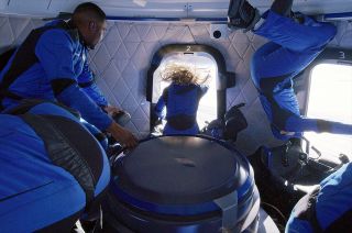 With her hair floating in the weightless environment of space, Laura Shepard Churchley looks out one of the large windows aboard Blue Origin's New Shepard capsule during the NS-19 suborbital flight on Dec. 11, 2021.
