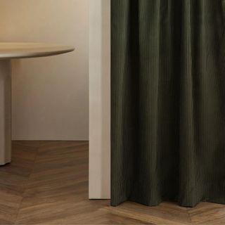 A green curtain panel in a neutral room