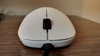 A white Endgame Gear XM1r gaming mouse on a wooden table