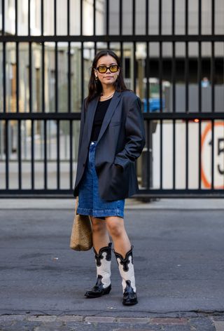 woman wearing leather blazer over t-shirt with denim shorts and cowboy boots