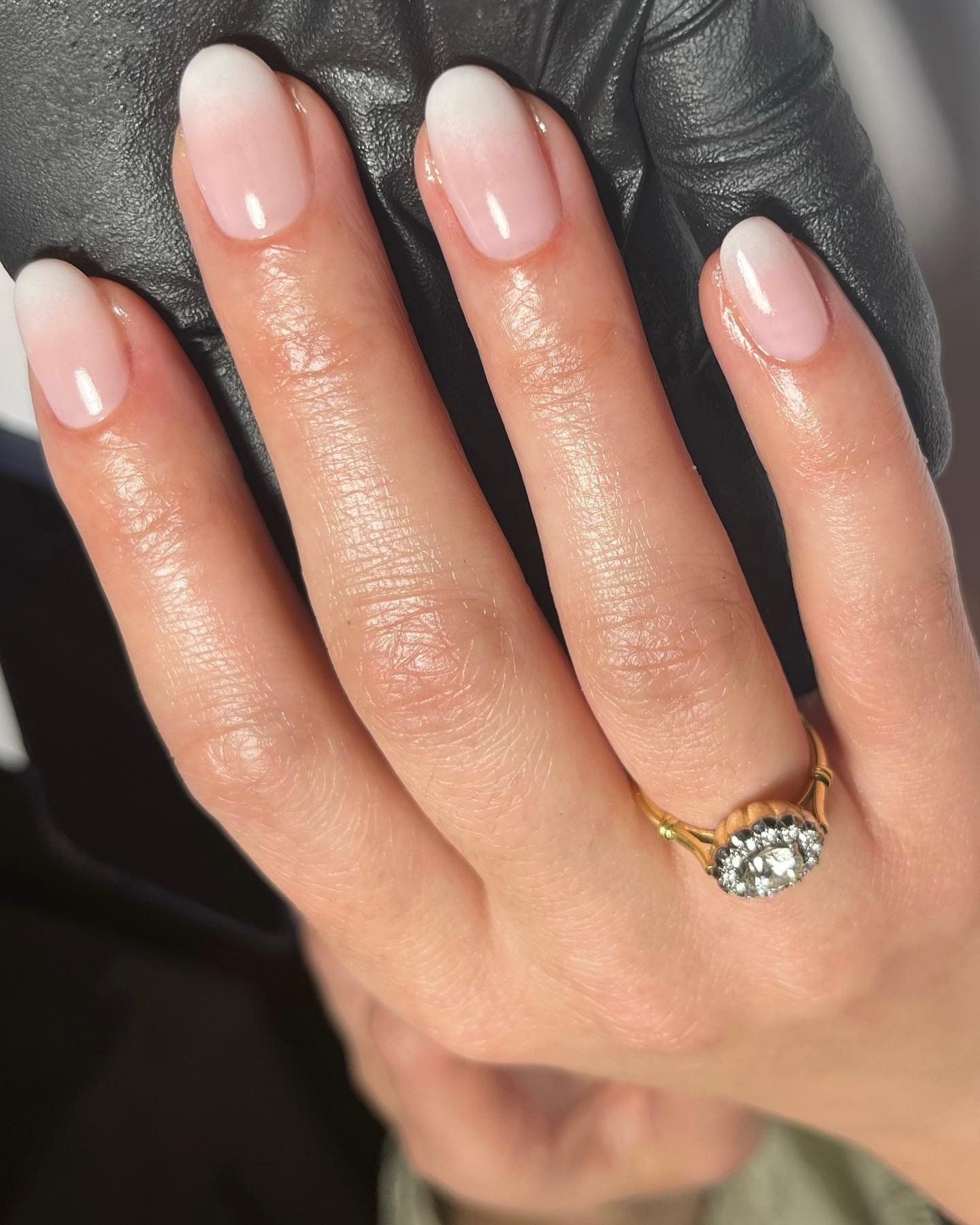 A woman's hand showing off a blurred French manicure nail design