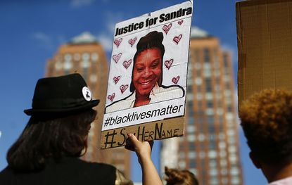 A protester holds a Sandra Bland poster.