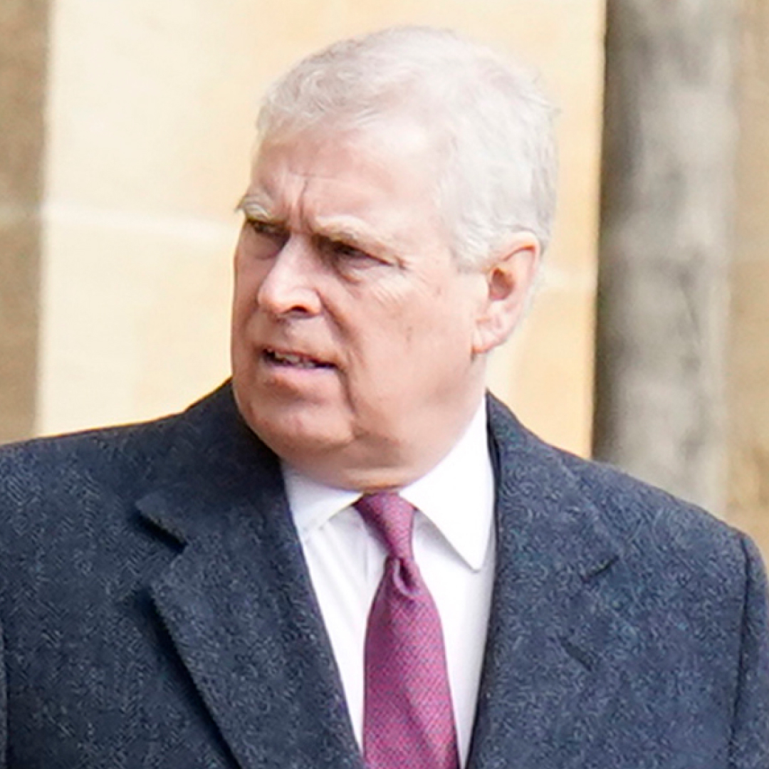 Ex-Prince Andrew looks shocked while wearing a dark gray overcoat with a white shirt and red and purple tie