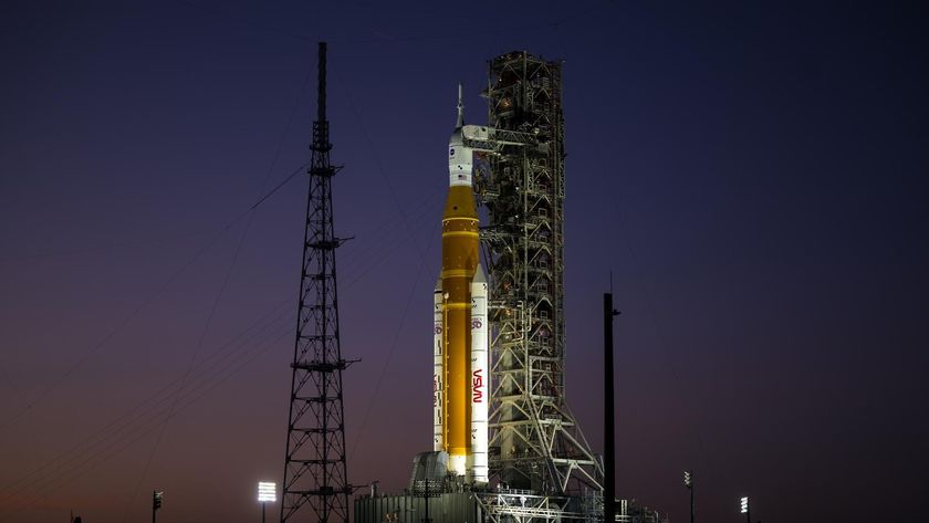 an orange rocket on a launch pad at sunset