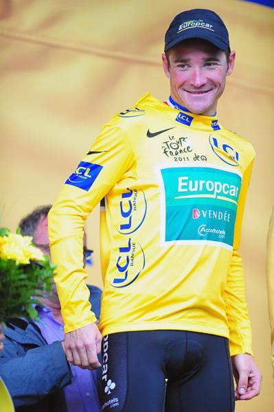 Five-time Tour winner Bernard Hinault assists Thomas Voeckler into the yellow jersey.