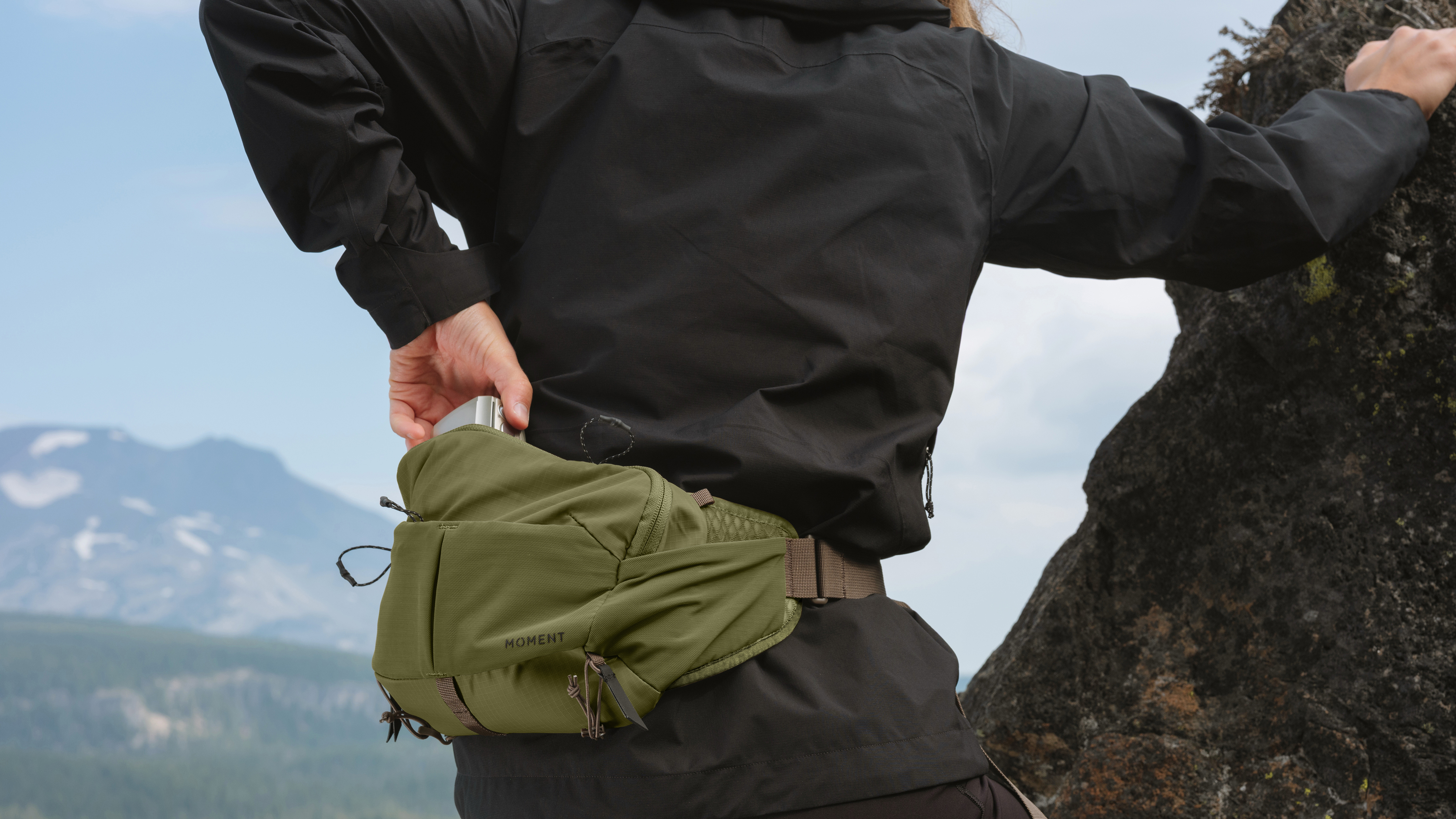 A photographer wearing the Moment Slate Sling