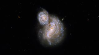 The Hubble Space Telescope observes a pair of spiral galaxies swirling together.
