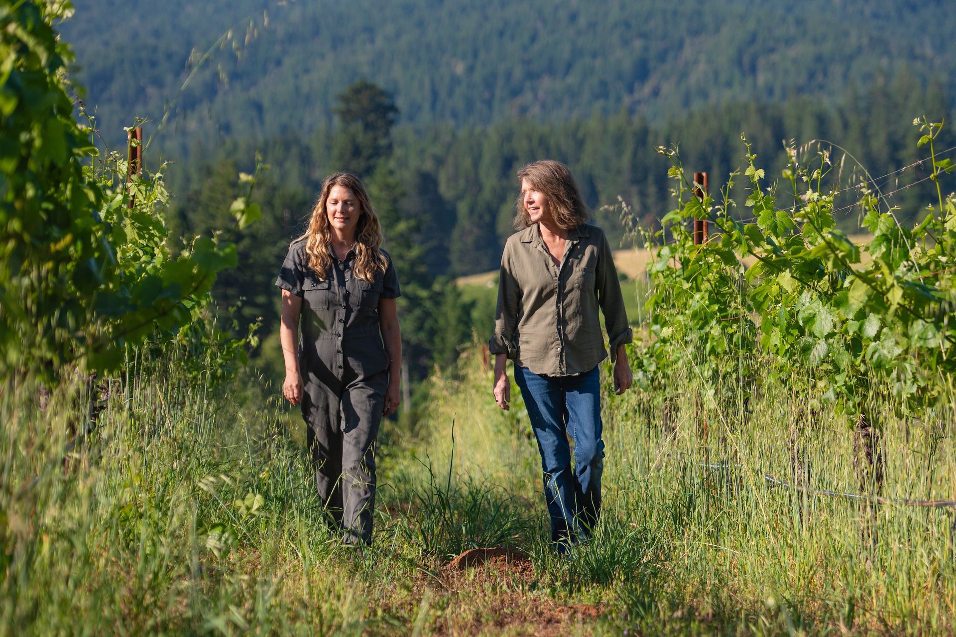 Brashley Vineyards winemaker Ashley Holland and co-owner Ashley Palm walk through an Anderson Valley vineyard with a tall cover crop.