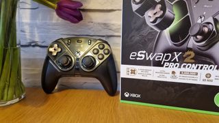 The Thrustmaster eSwap X2 controller on a wooden surface