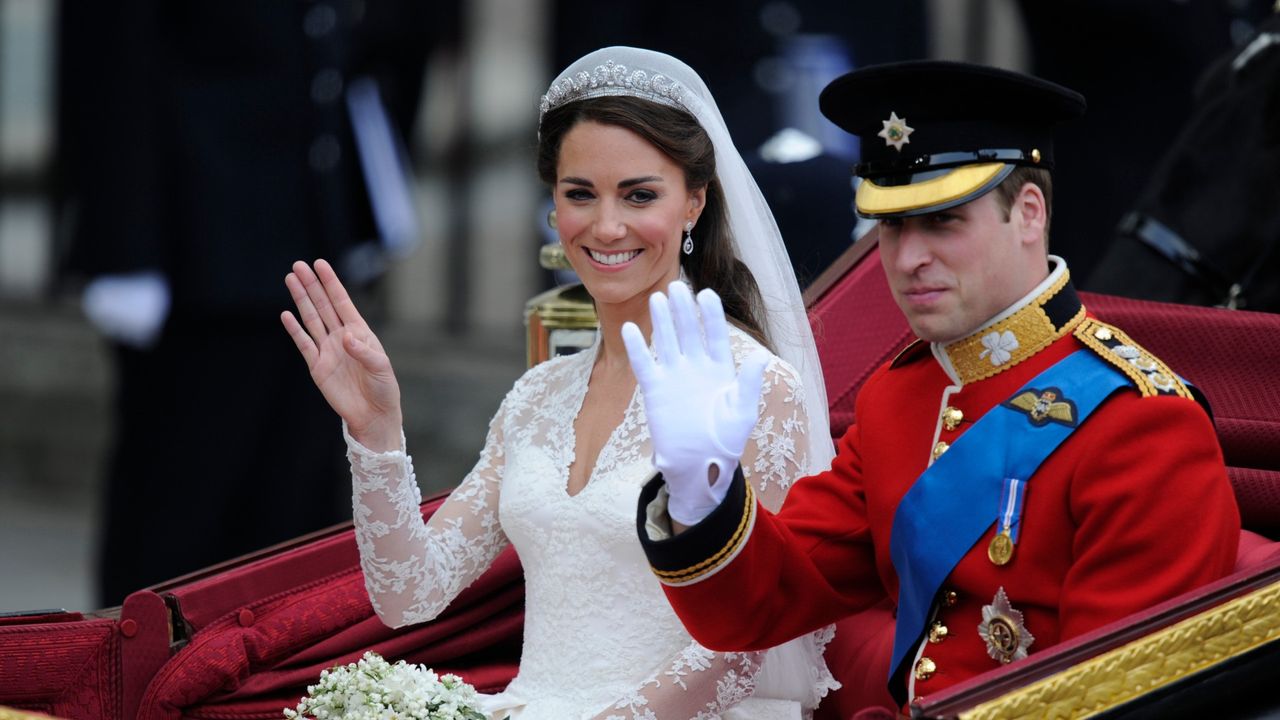 Britain&#039;s Prince William and his wife Kate, Duchess of Cambridge, wave as they travel in the 1902 State Landau carriage along the Processional Route to Buckingham Palace