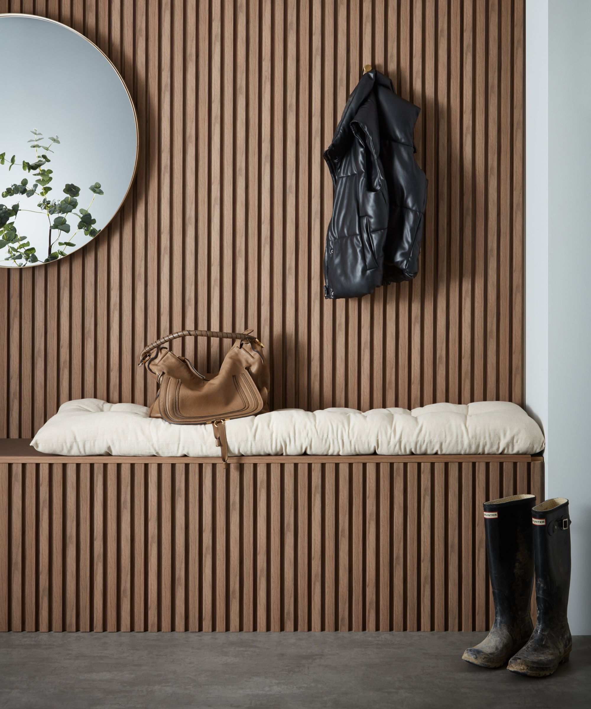 A hallway with a slatted wood wall and a built in storage bench