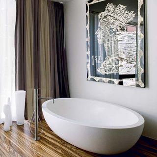 bathroom with wooden flooring and white bathtub