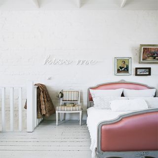 bedroom with white brick wall and wooden flooring