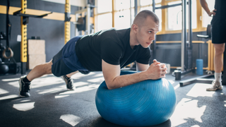 Man performing a plank on an exercise ball