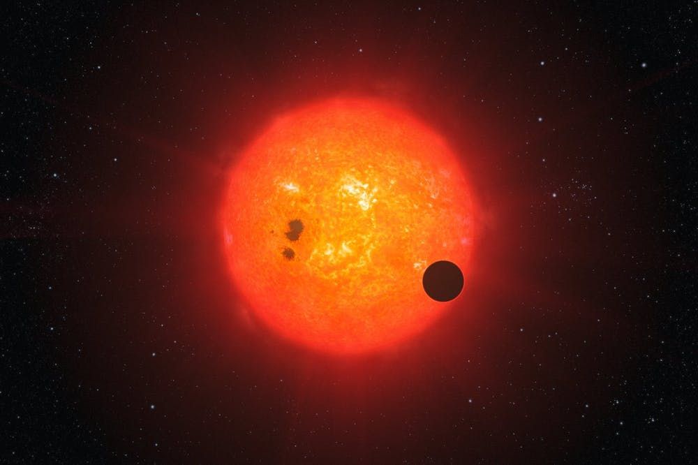 Artist&#039;s impression of an exoplanet transiting a red dwarf star.