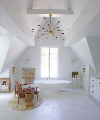 An example of master bathroom ideas showing a white bathroom with a vaulted, beamed ceiling, painted all-white with a brass and a contemporary chandelier