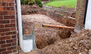 foundation dugging out for house extension with brick wall and mud