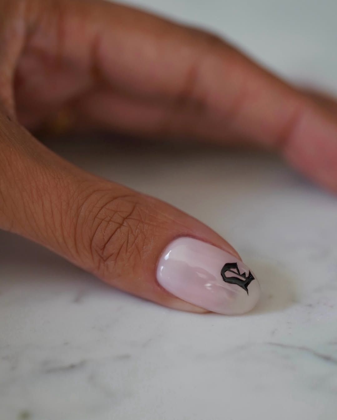 A clean manicure with an old english initial letter by Iram Shelton