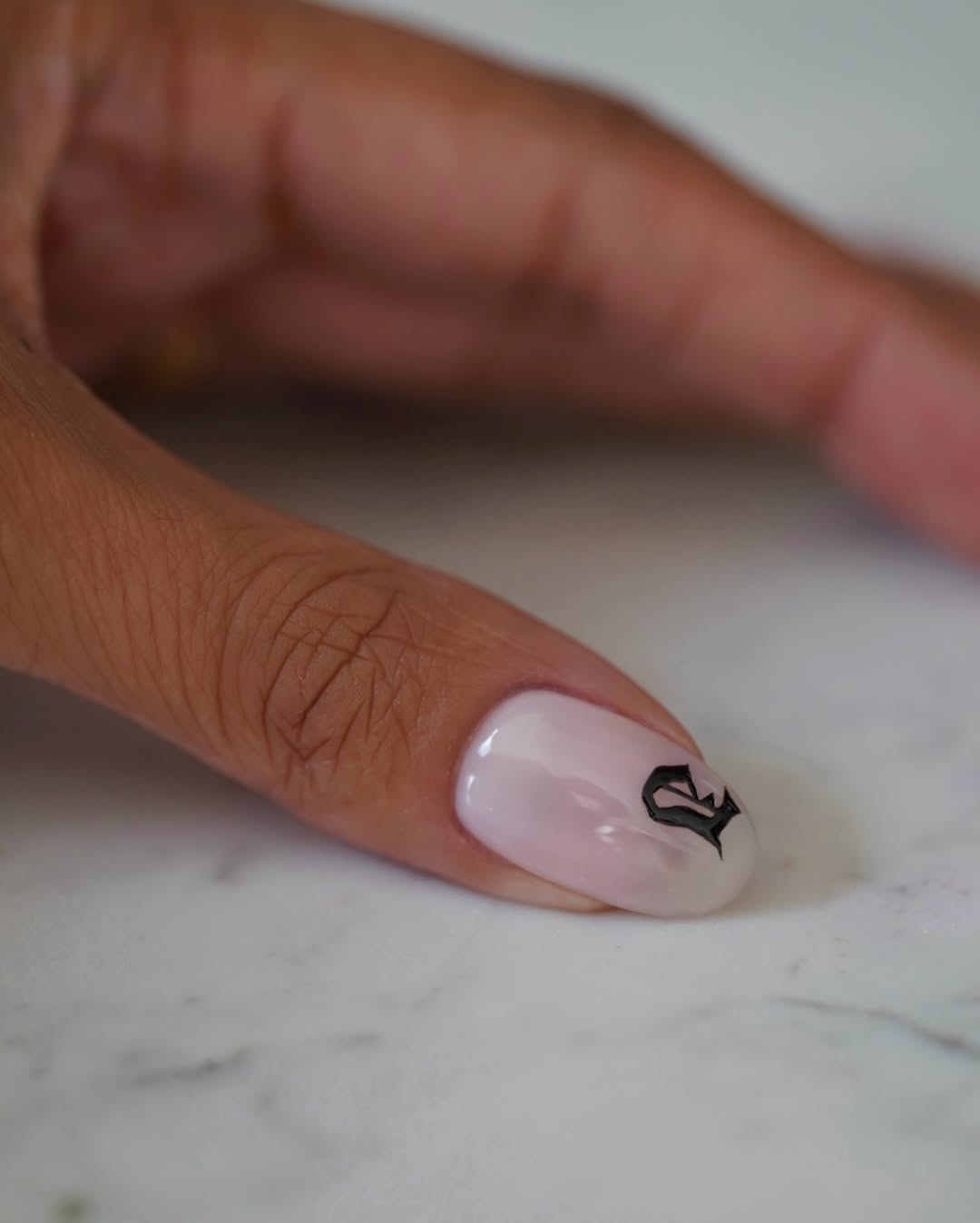 A clean manicure with an old english initial letter by Iram Shelton