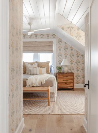 bedroom with pretty floral wallpaper, panel ceiling, white bed frame, timber side table and jute rug