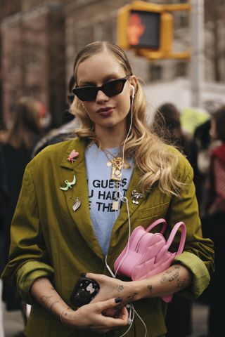 A woman at new york fashion week wearing a brooch in a street style outfit