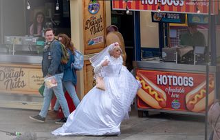 Jean Slater running in a wedding dress at a theme park.