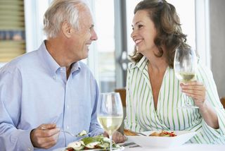 An older couple drinks wine together at a restaurant.