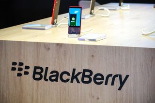 A BlackBerry phone on display above the BlackBerry logo