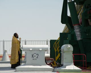 An Orthodox priest blesses the Soyuz rocket at the Baikonur Cosmodrome Launch pad on Friday, July 13, 2012 in Kazakhstan.